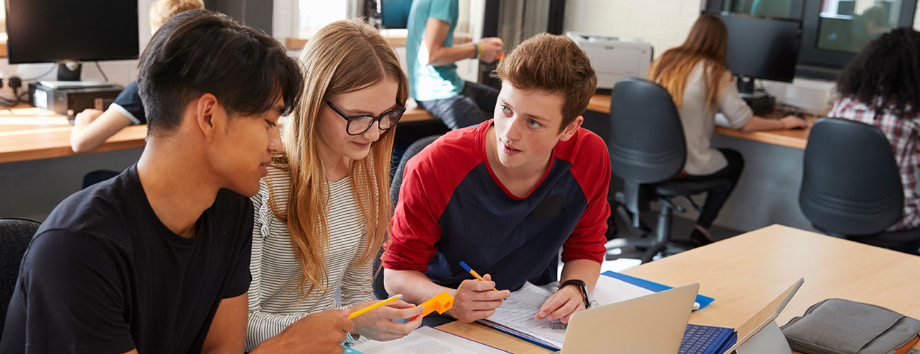 Three CAPS students discussing and working on a project